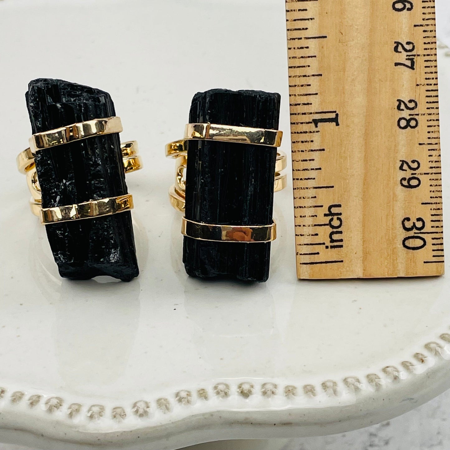 tourmaline rods next to a ruler for size reference 