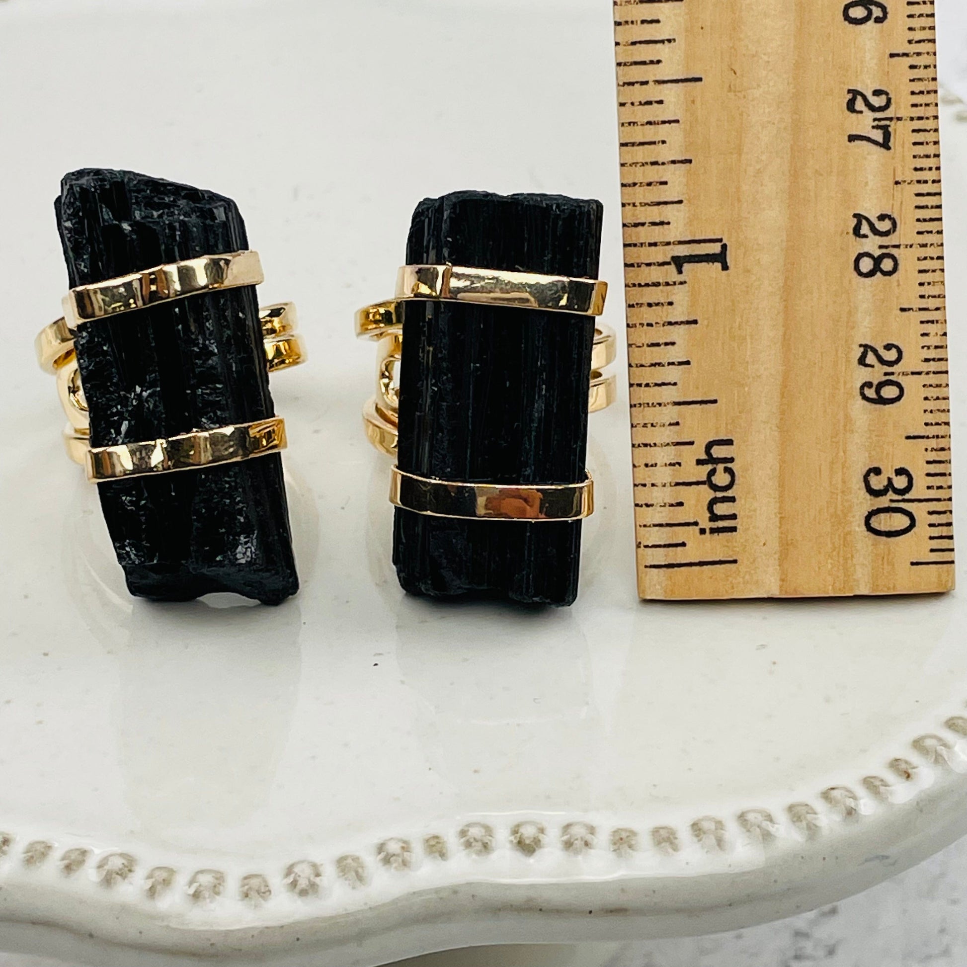 tourmaline rods next to a ruler for size reference 