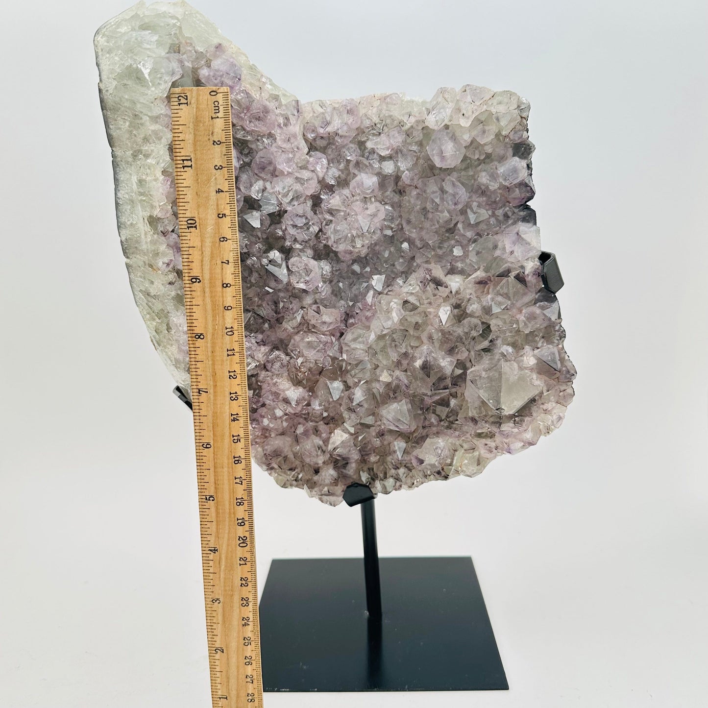 crystal on stand next to a ruler for size reference 