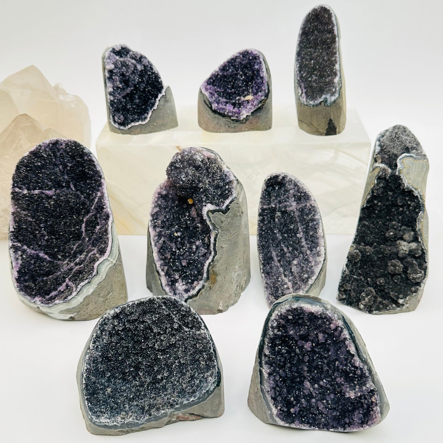multiple black amethyst druzy cut base crystals displayed to show the differences in the sizes and color shades 