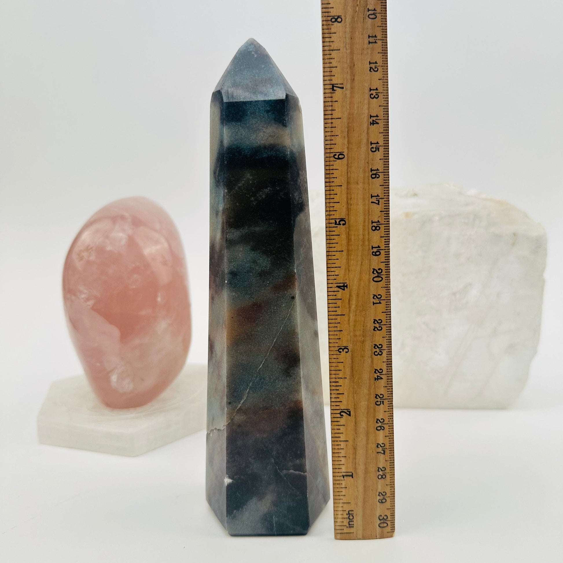 polished trolleite crystal point displayed next to a ruler for size reference 