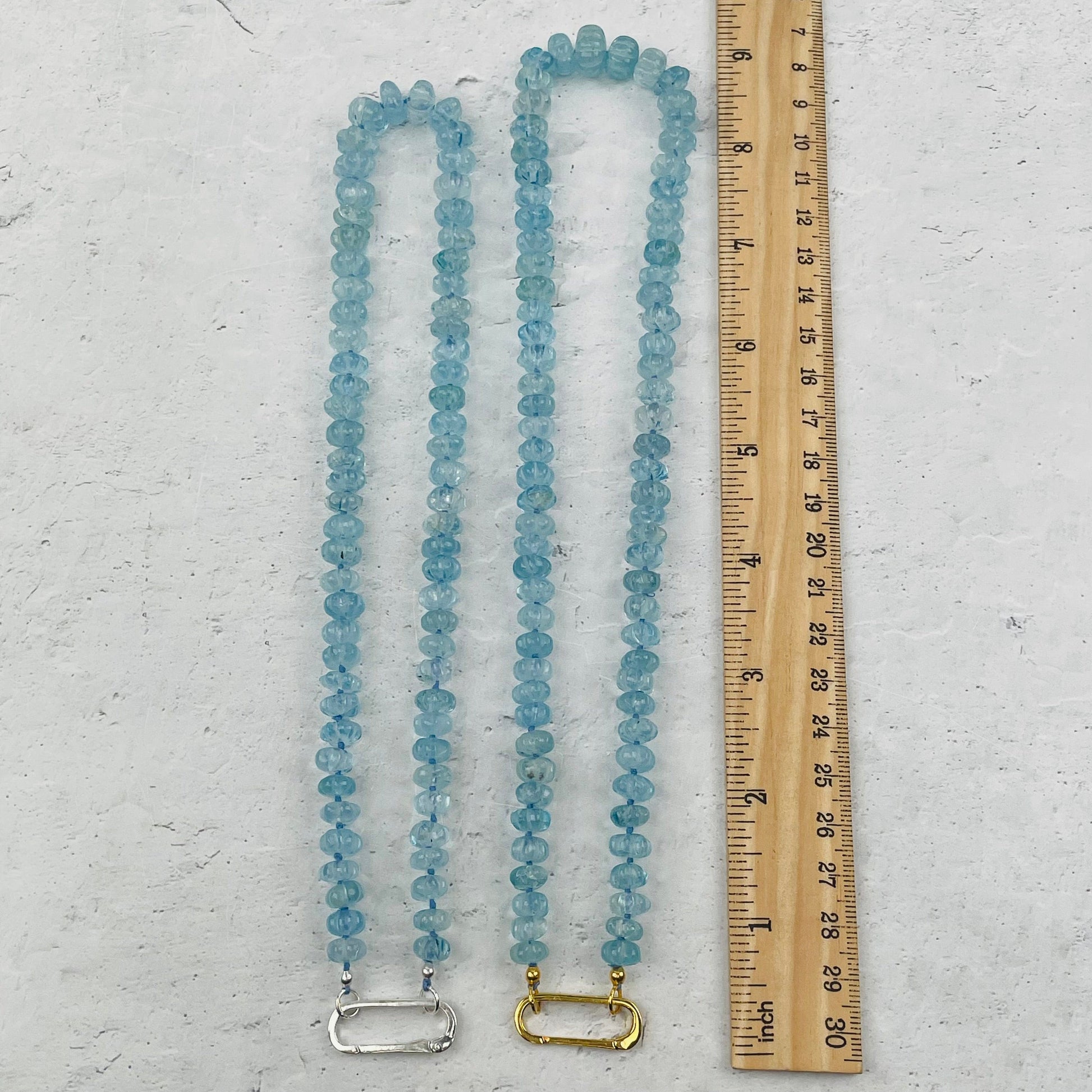 necklaces next to a ruler for size reference 