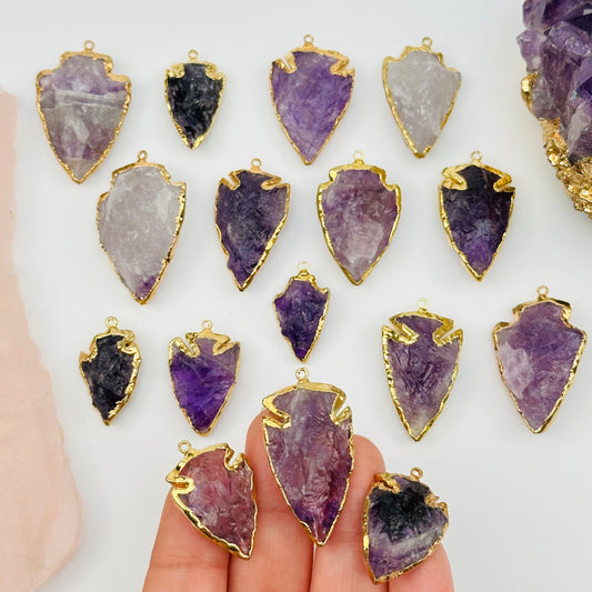 amethyst arrowhead pendant charm with 24k gold electroplated edges on hand for size reference 