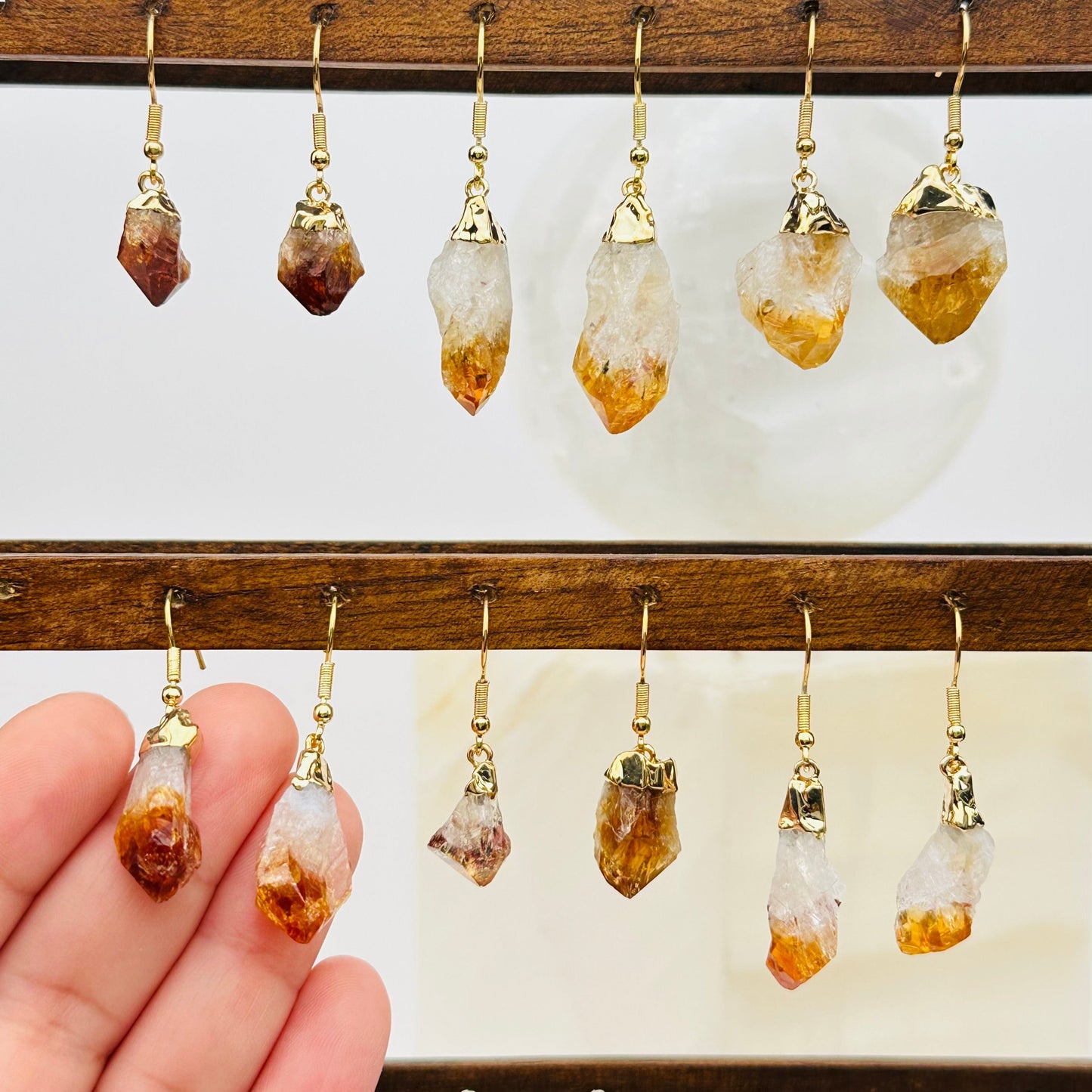 multiple citrine earrings displayed to show the differences in the sizes and color shades