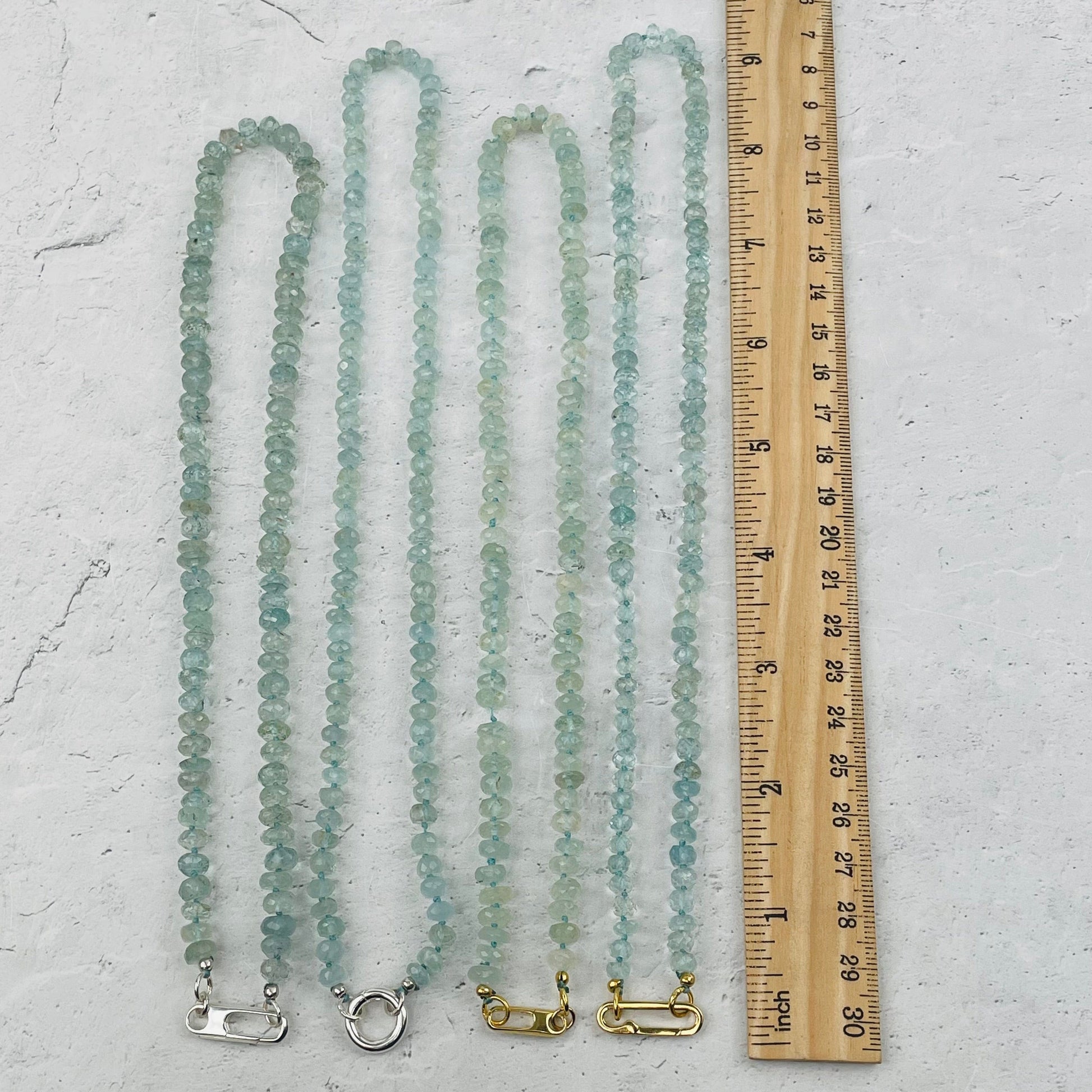 necklaces next to a ruler for size reference 