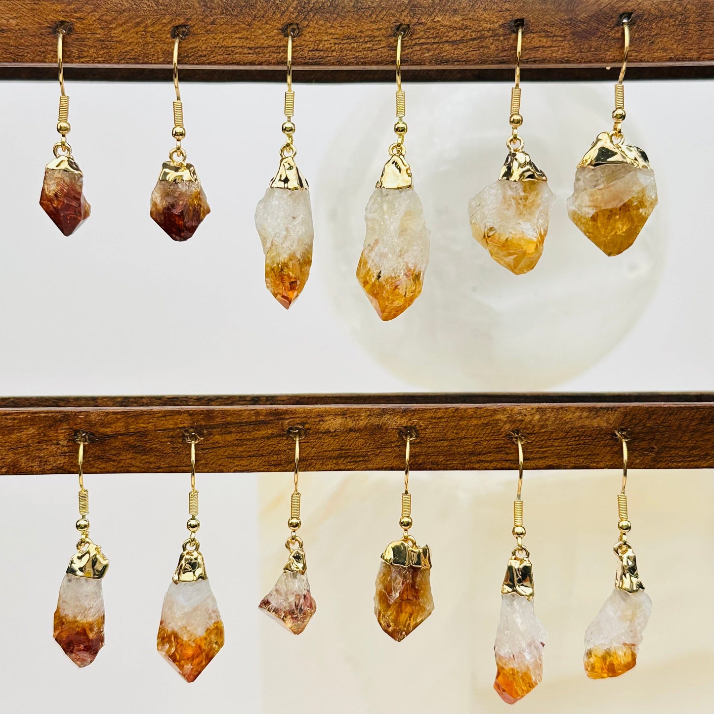 multiple citrine earrings displayed to show the differences in the sizes and color shades