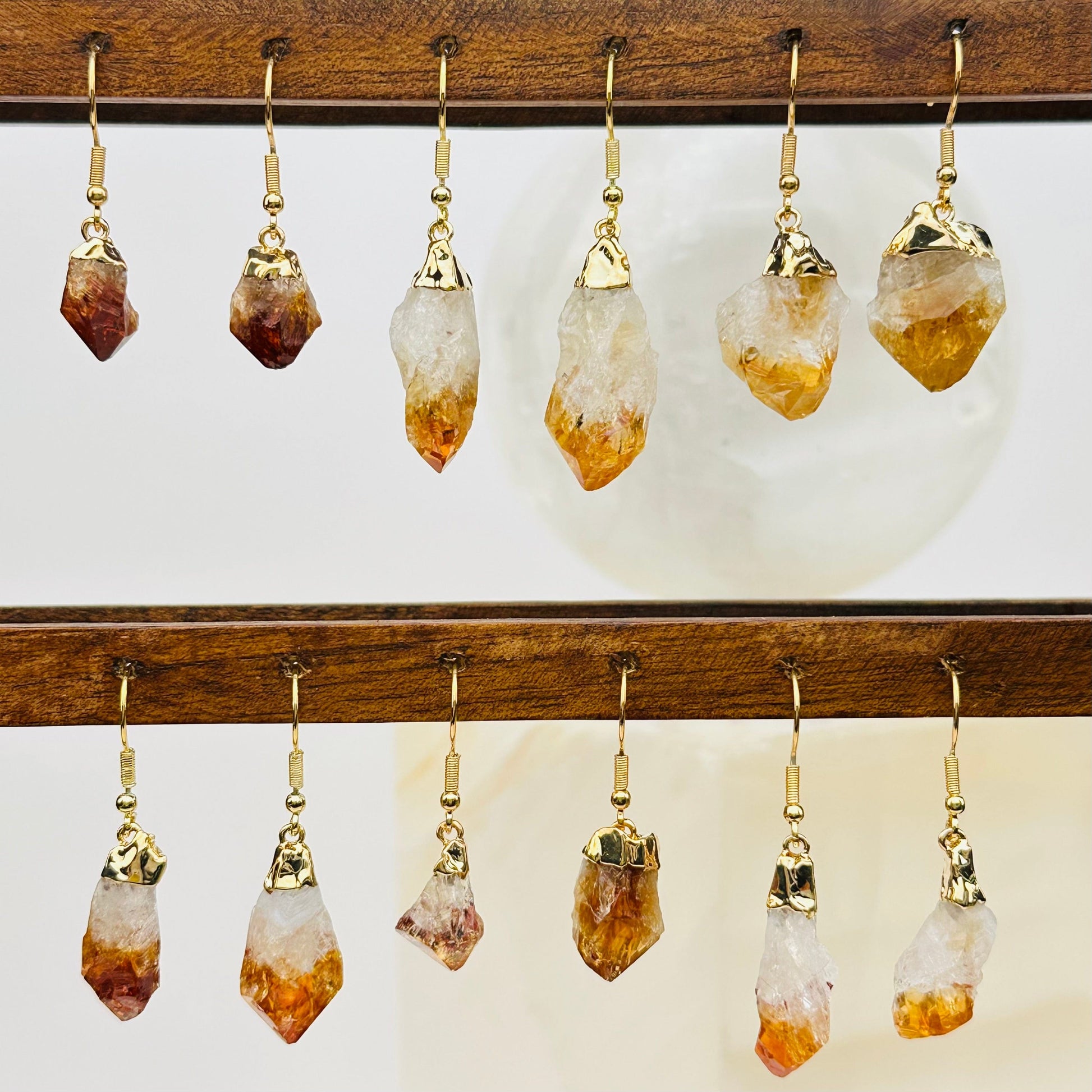 multiple citrine earrings displayed to show the differences in the sizes and color shades