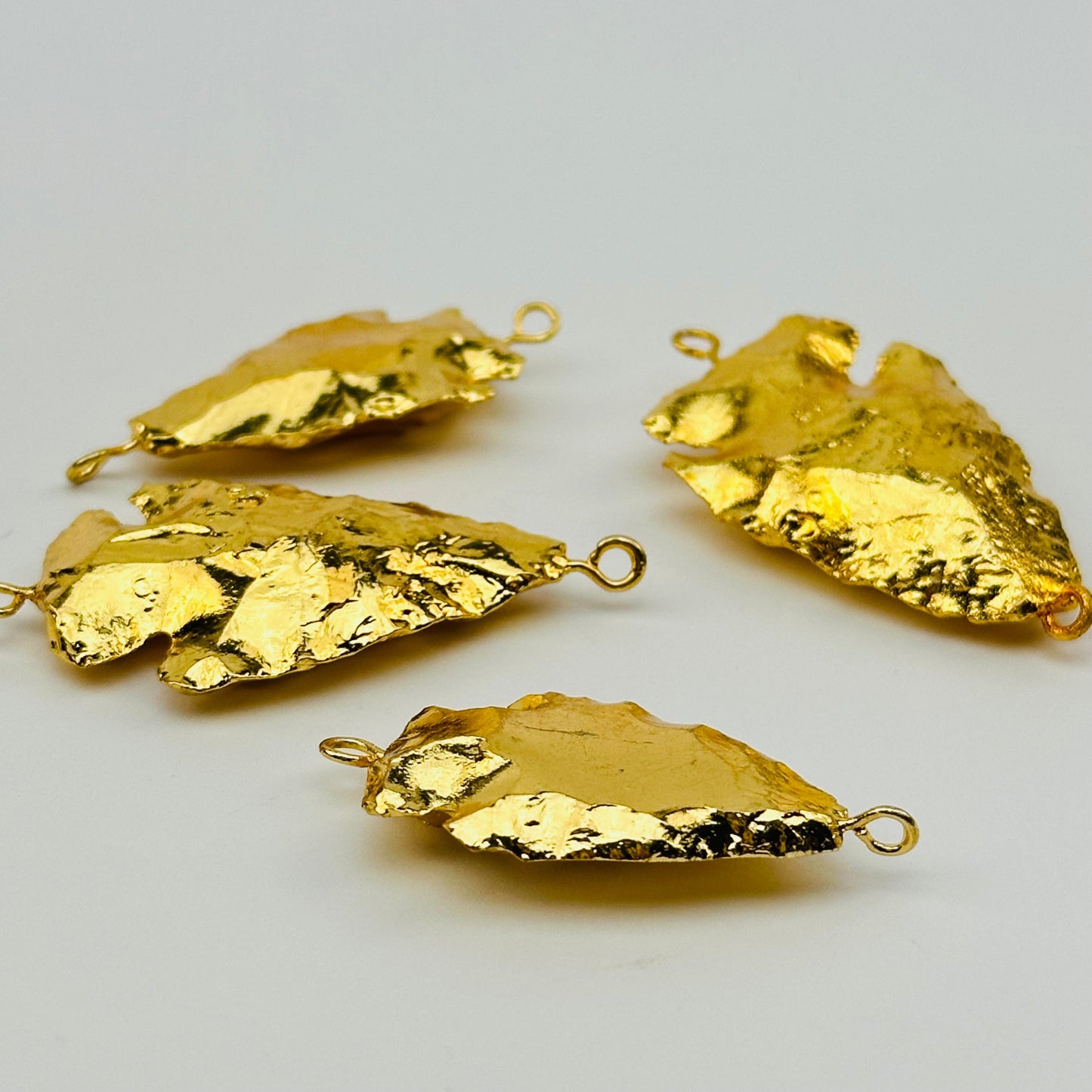 close up of the details on these 24k gold electroplated pendant charms 