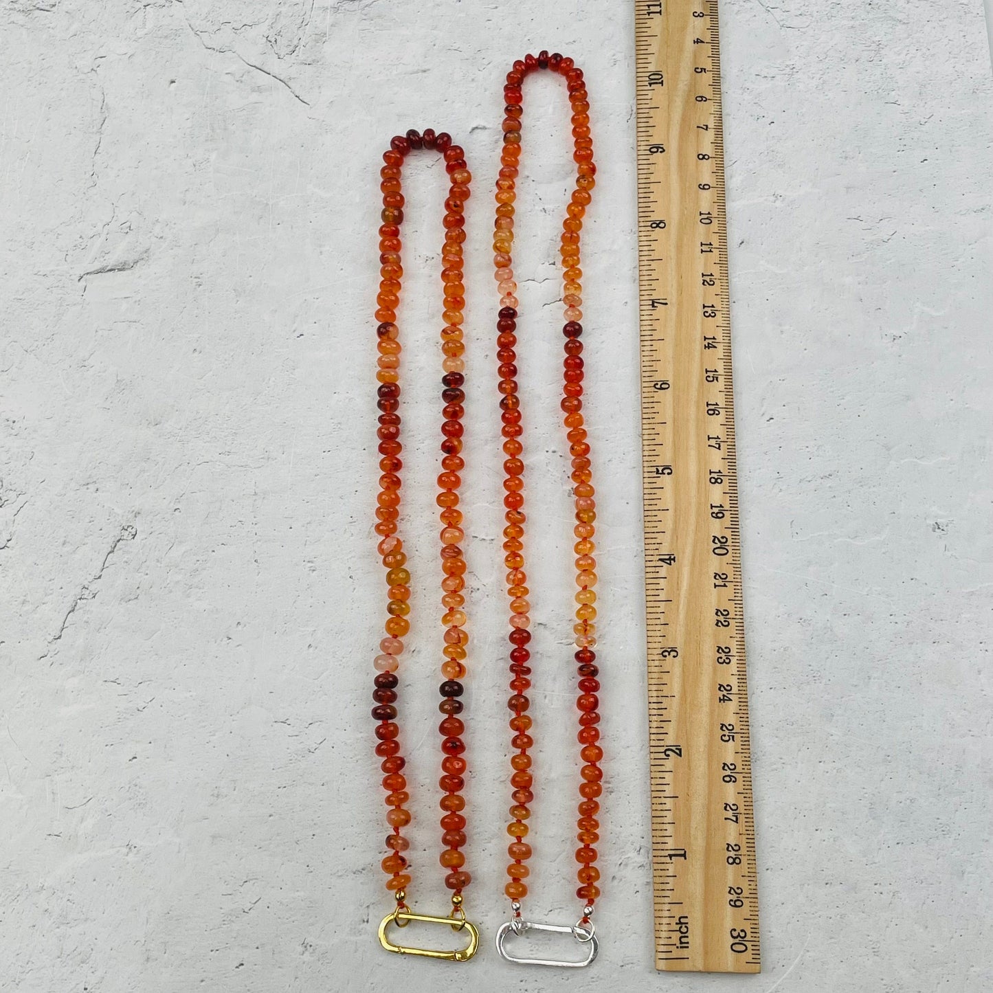 necklaces next to a ruler for size reference 