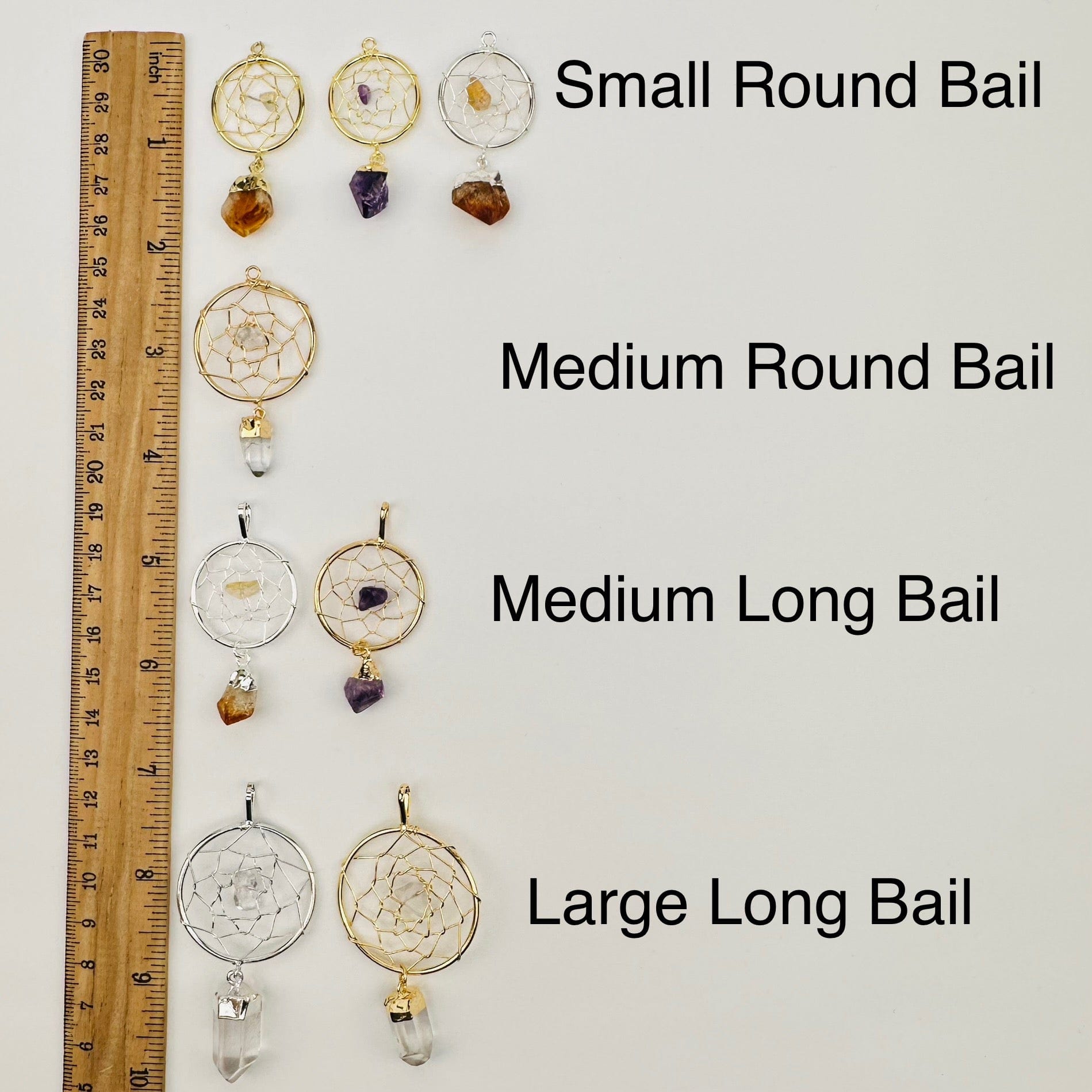 pendants displayed next to a ruler to show the differences in the sizes and bails 