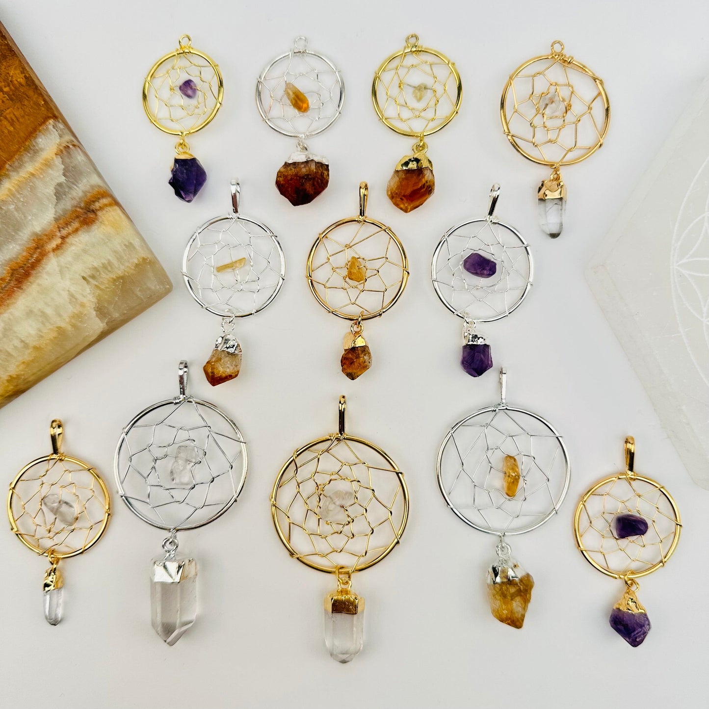 multiple dream catcher pendants displayed to show the differences in the sizes and crystal types 