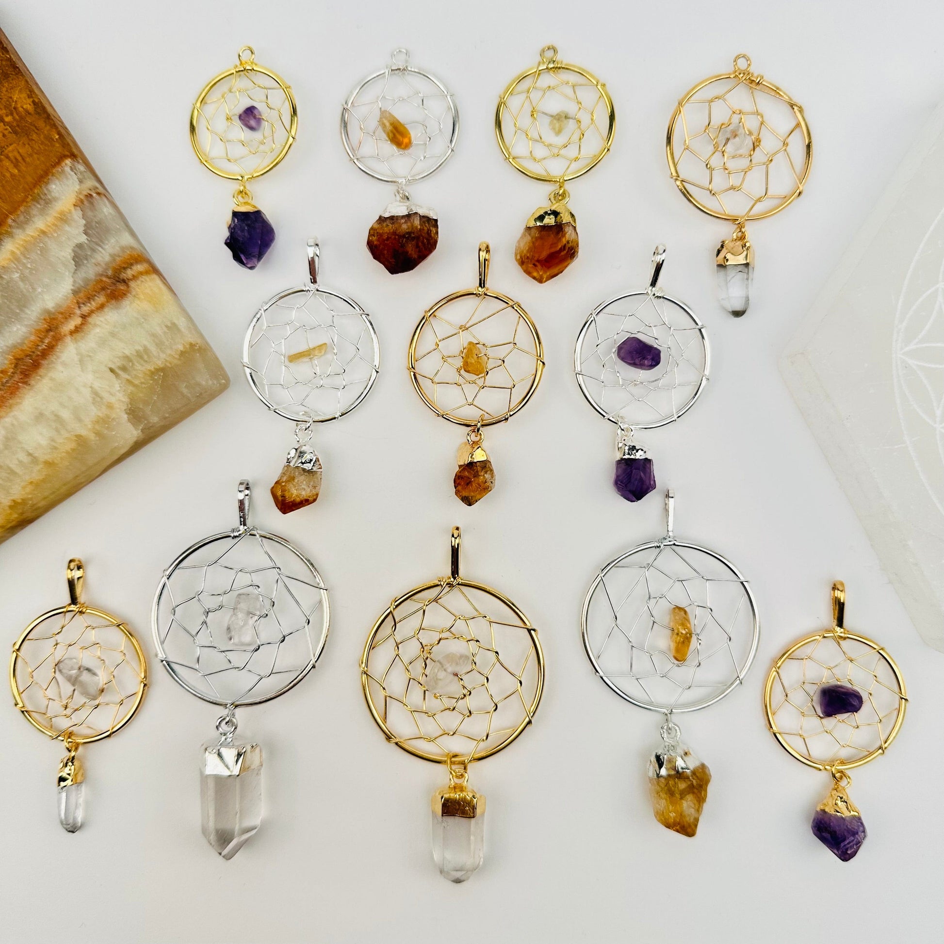 multiple dream catcher pendants displayed to show the differences in the sizes and crystal types 