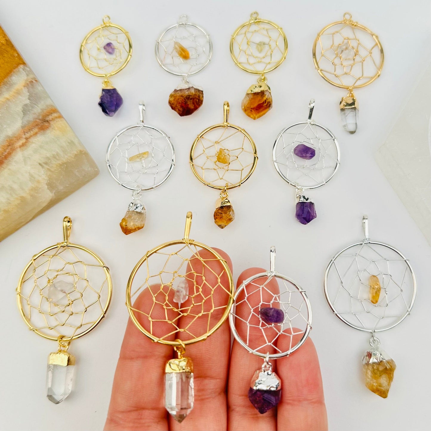 multiple dream catcher pendants displayed to show the differences in the sizes and crystal types 