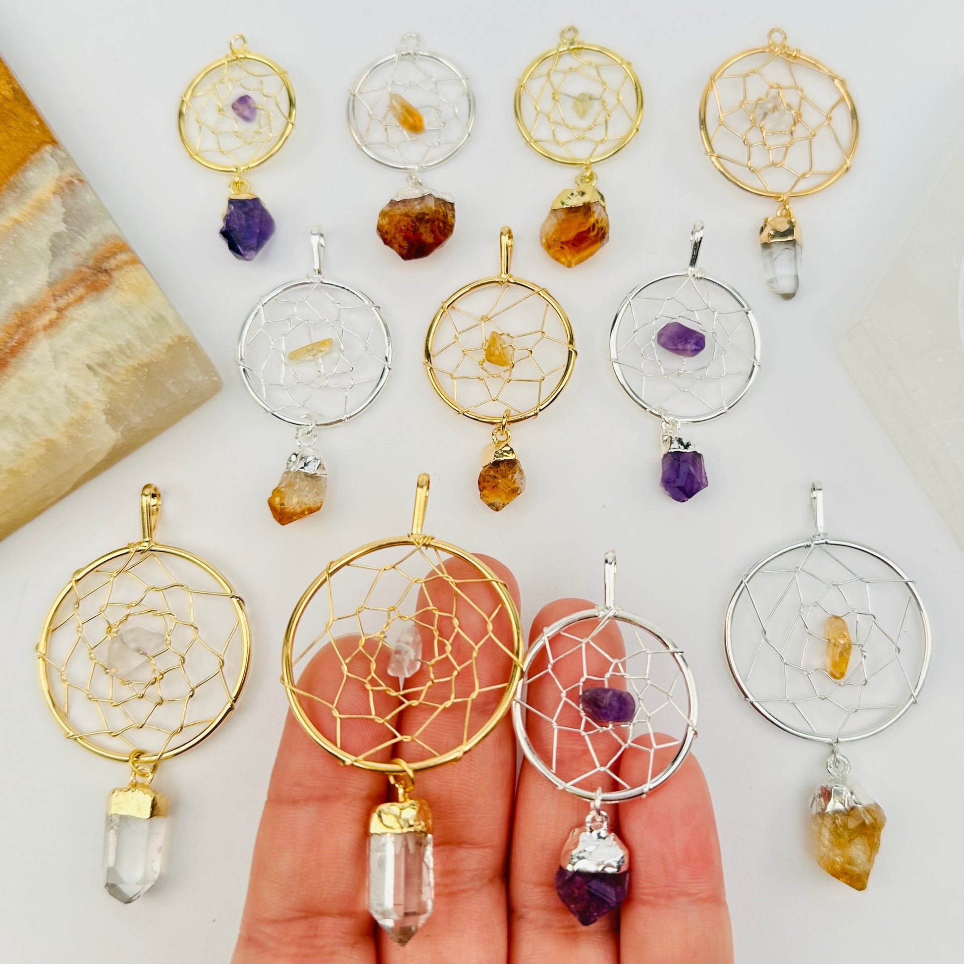 multiple dream catcher pendants displayed to show the differences in the sizes and crystal types 