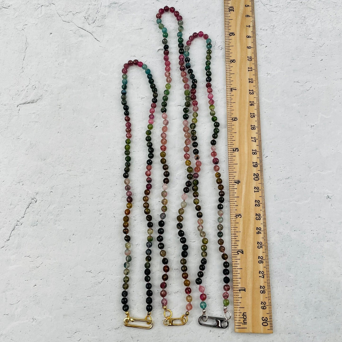 necklaces next to a ruler for size reference 