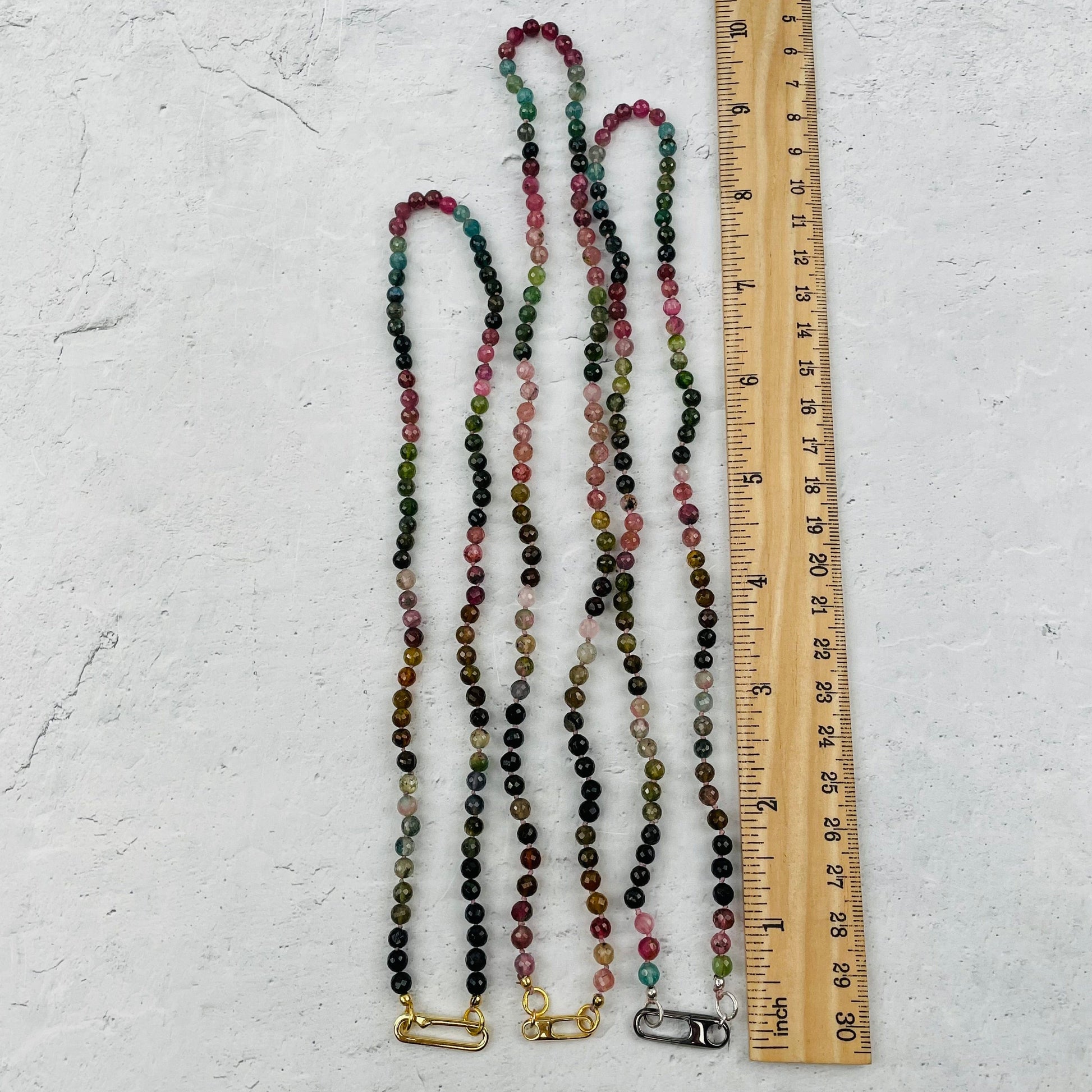 necklaces next to a ruler for size reference 