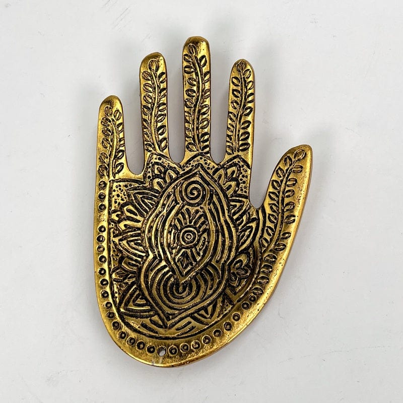 close up of the details on the gold toned hand incense burner