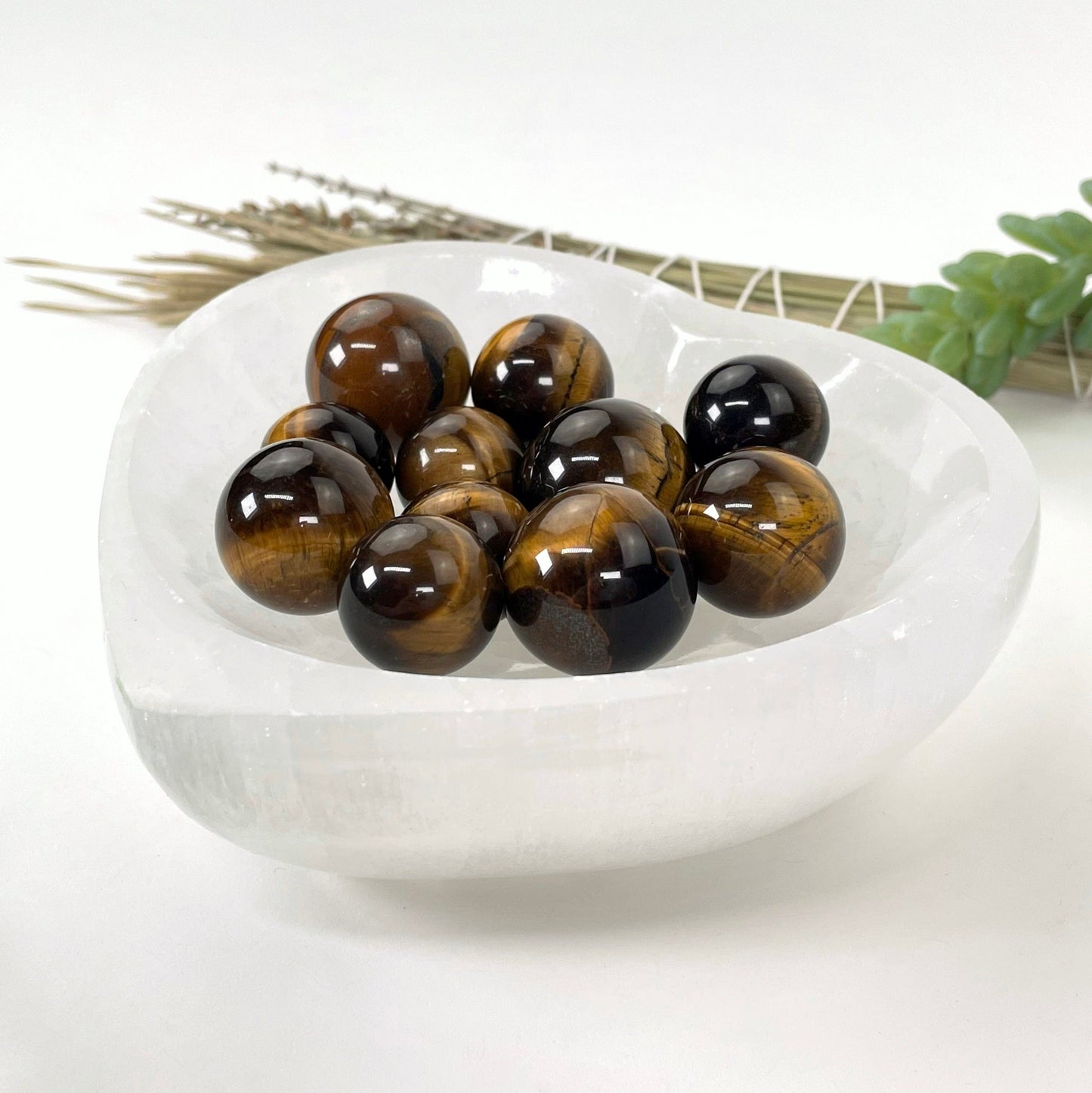 angled view of many tigers eye spheres in a heart bowl for thickness