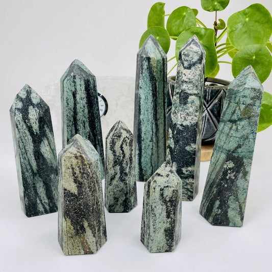 multiple green snakeskin jasper polished points displayed to show the differences in the sizes available 