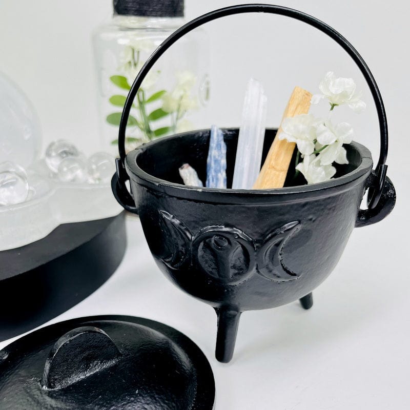 metal cauldron made out of metal and accented with the moon phase in the front and back 