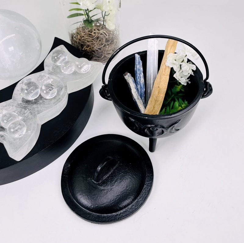 caldron with some stones, sacred wood and flowers set as home decor 