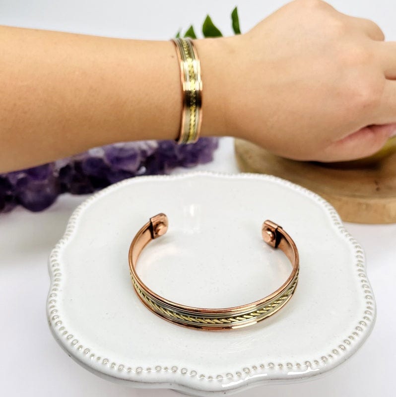 close up of the details on this copper bracelet with a center twist design 