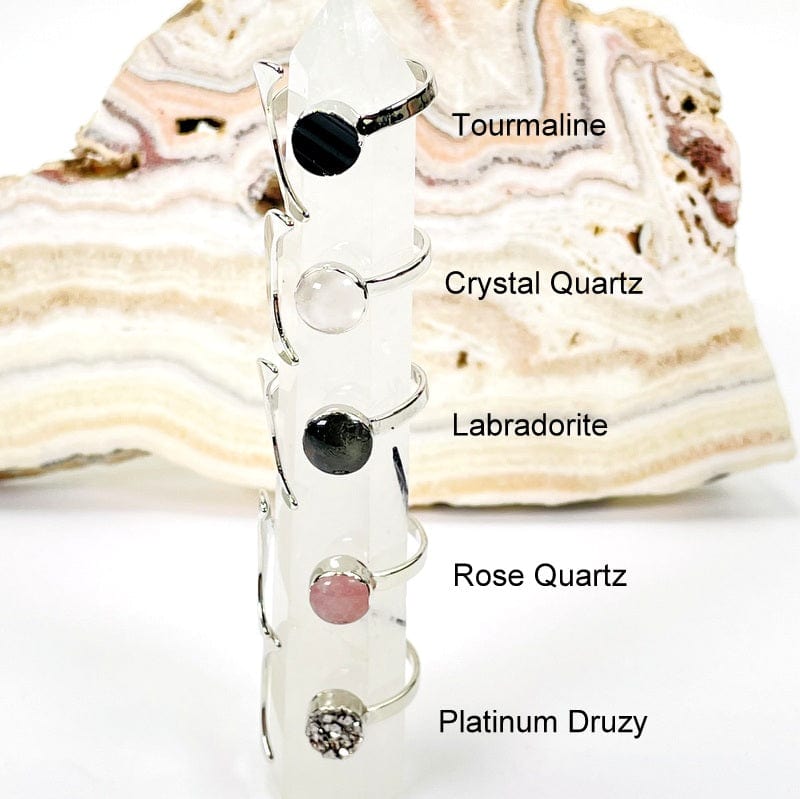 close up of silver moon rings with gemstone accent and their name next to it