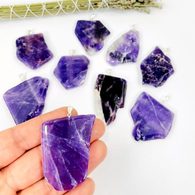 amethyst slab pendant with silver bail in hand showing the size 