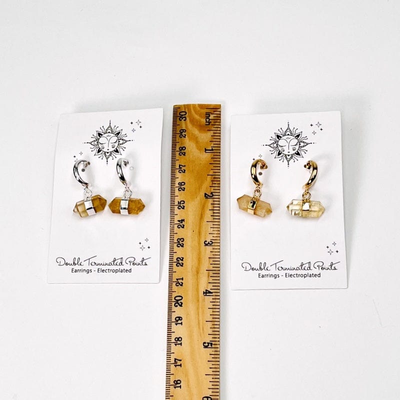 earrings next to a ruler for size reference 