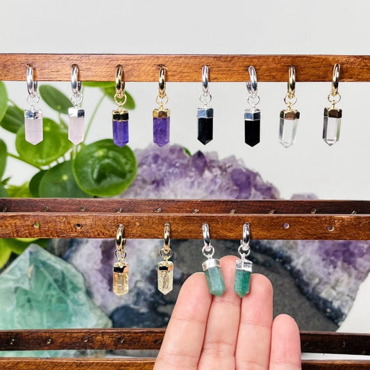 earrings displayed to show how they hang. one pair in finger tips to show the size 