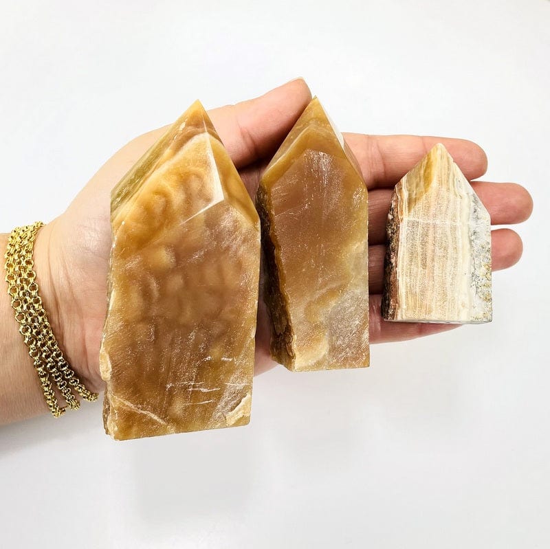 high grade aragonite semi polished points in hand for size reference 