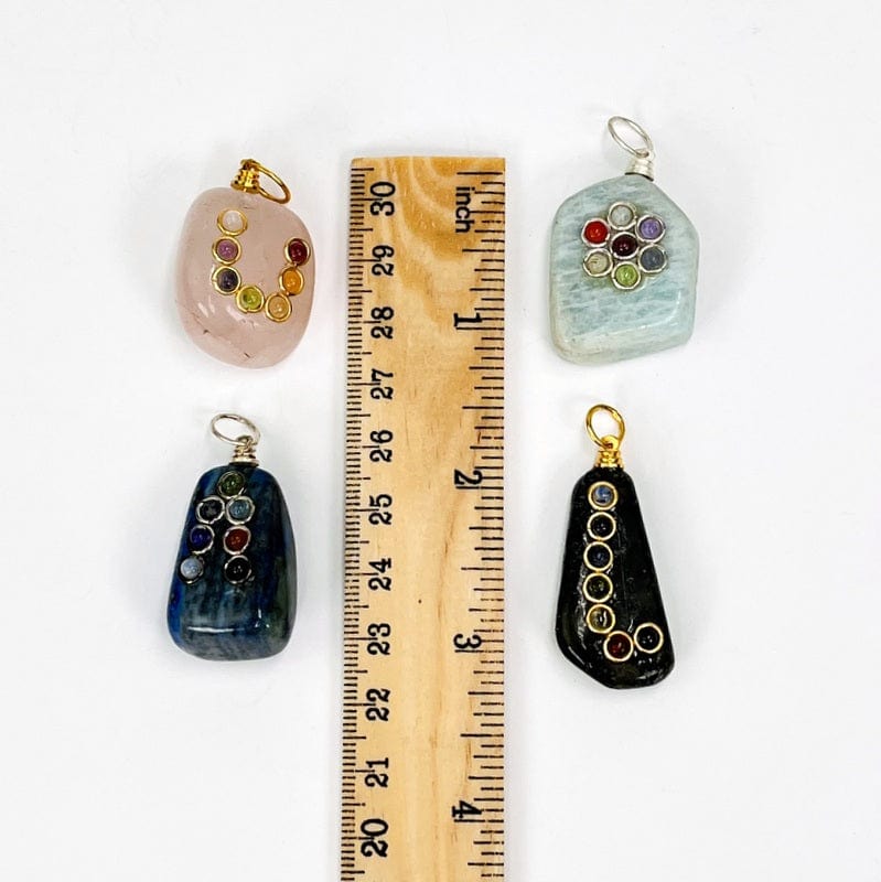 tumbled stones next to a ruler for size reference 