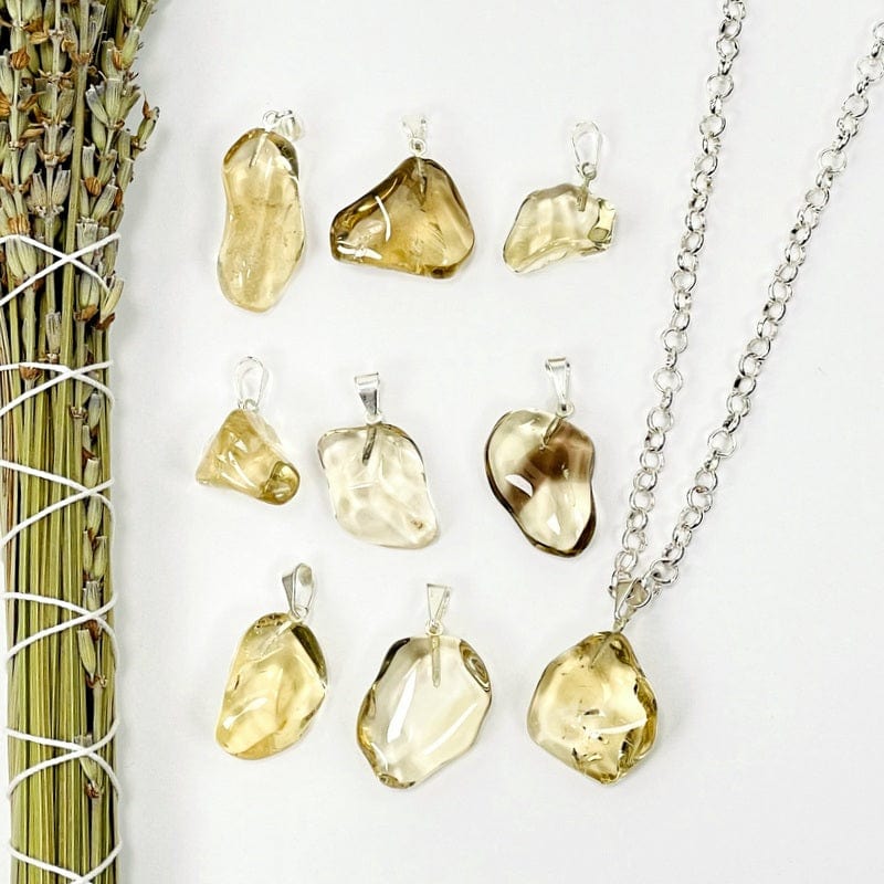Natural Citrine Tumbled Stone with a Silver Bail - 6 on a table
