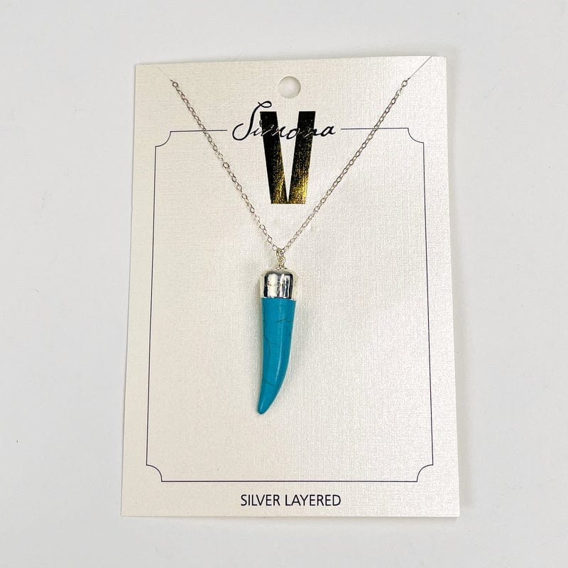close up of the details on the turquoise howlite horn pendant. comes with a silver cap and bail on a silver chain