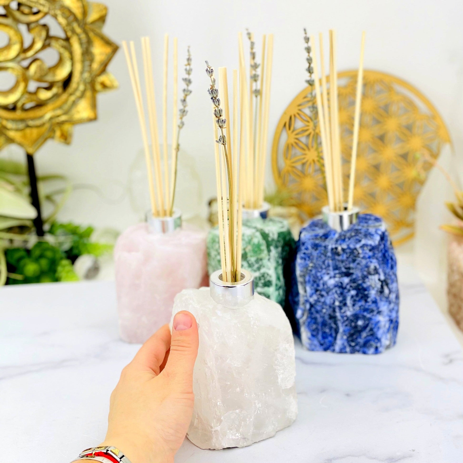 1 Rough Stone Diffuser Bottle up close while 3 others are blurred in the background with decorations