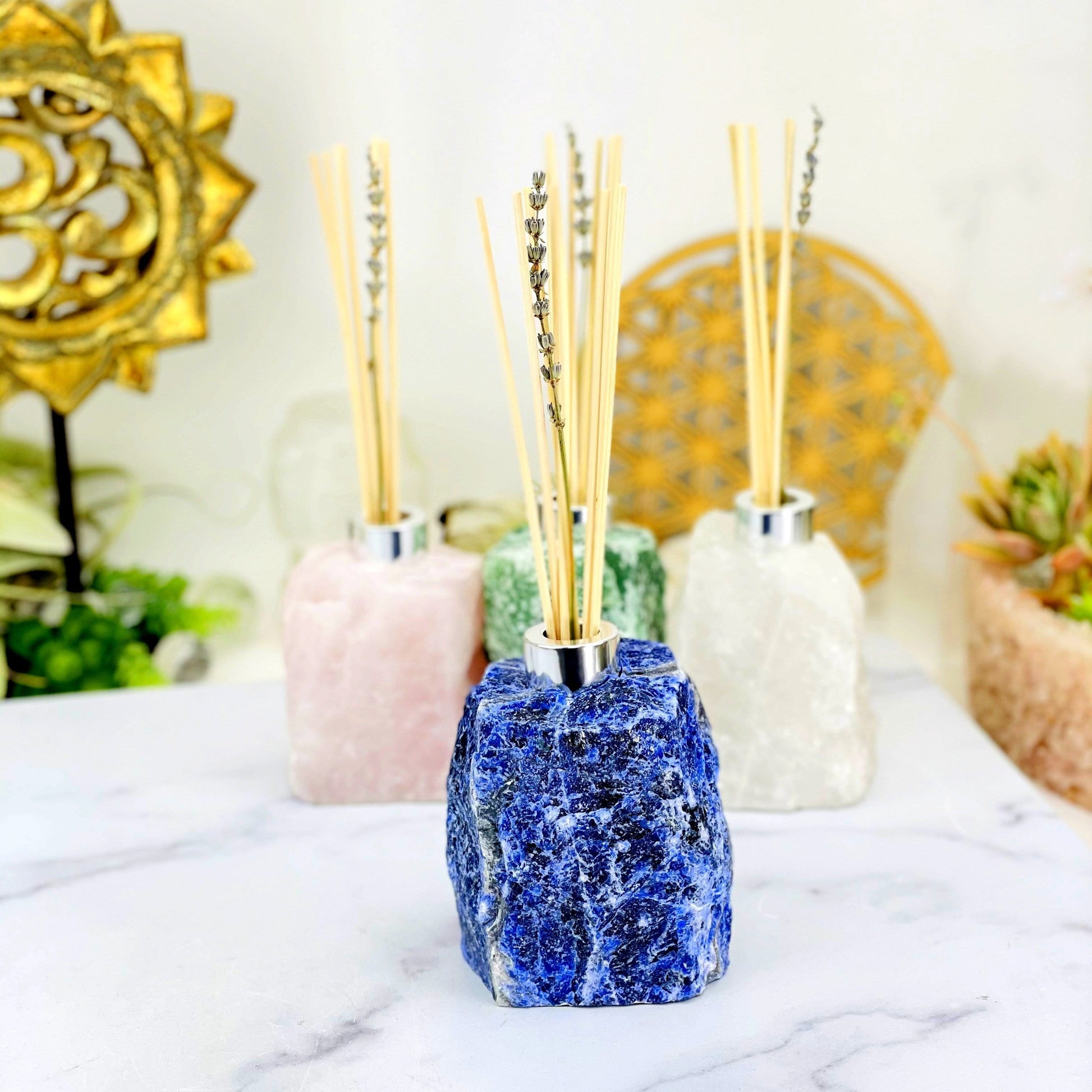 1 Rough Stone Diffuser Bottle up close while 3 others are blurred in the background with decorations