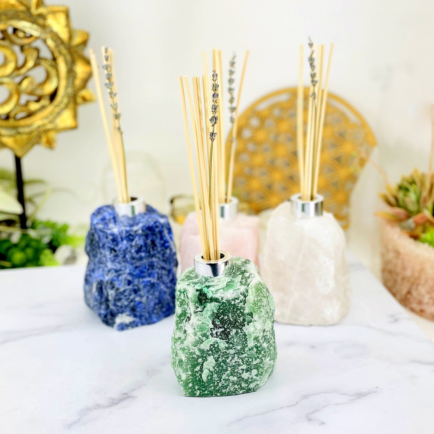 1 Rough Stone Diffuser Bottle up close while 3 others are blurred in the background with decorations