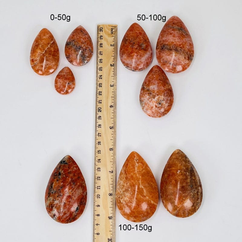orchid calcite drops next to a ruler for size reference 