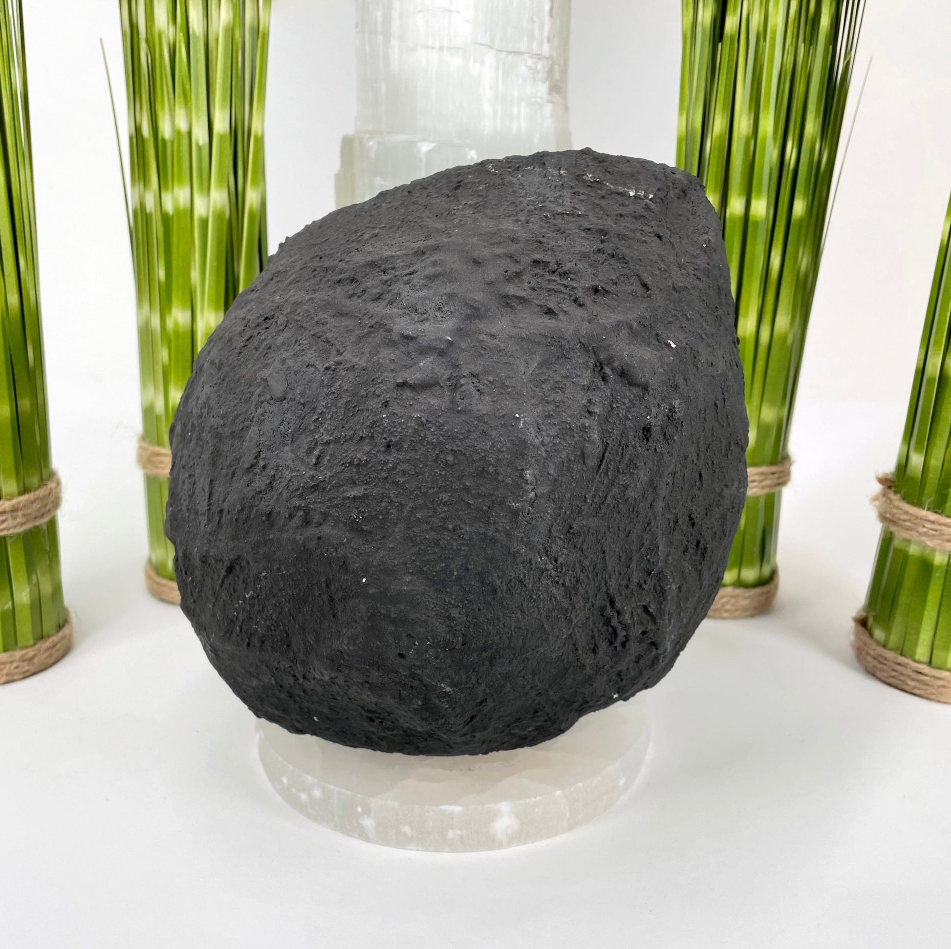 back of amethyst round cave geode on display in front of backdrop