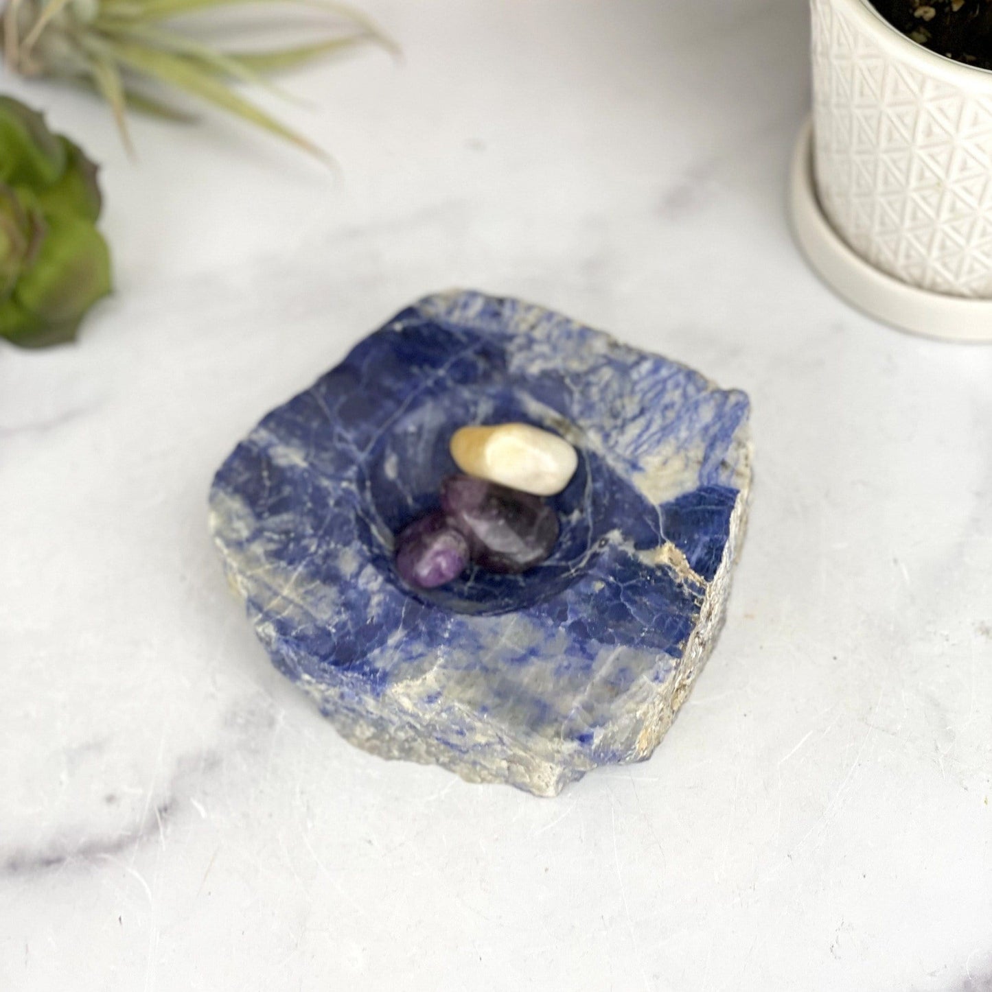 overhead view of sodalite polished soap dish with three stones inside for size reference