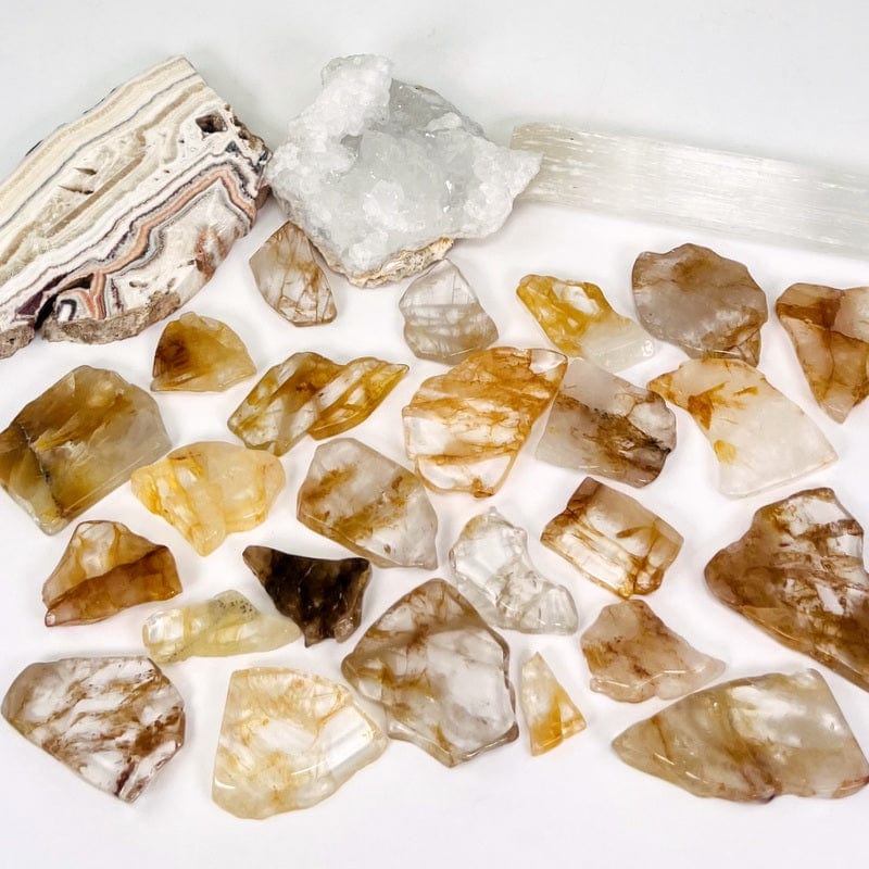 multiple golden healer stone semi polished slabs on white background displaying the different possible sizes and color patterns 