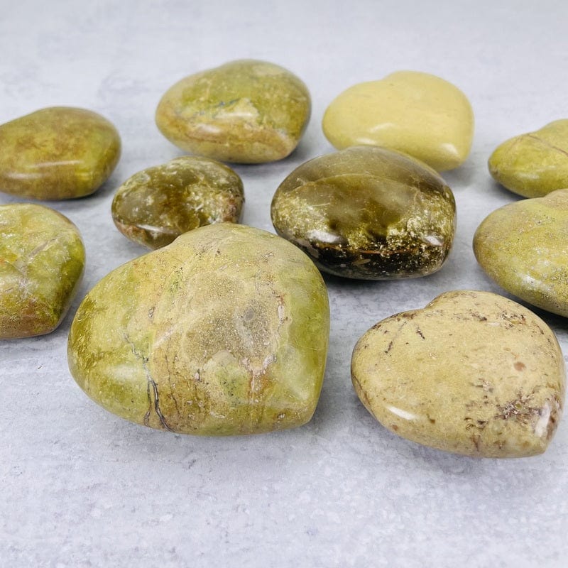 side shot of the green/pistachio opal polished hearts displaying the thicknesses 