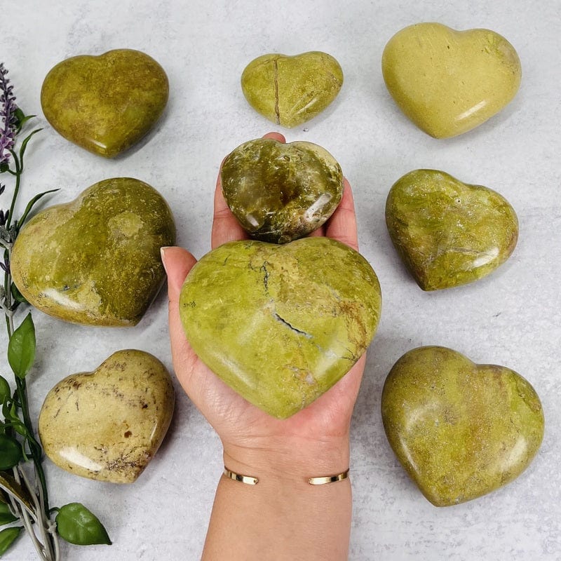 green/pistachio opal polished hearts in hand for size reference 