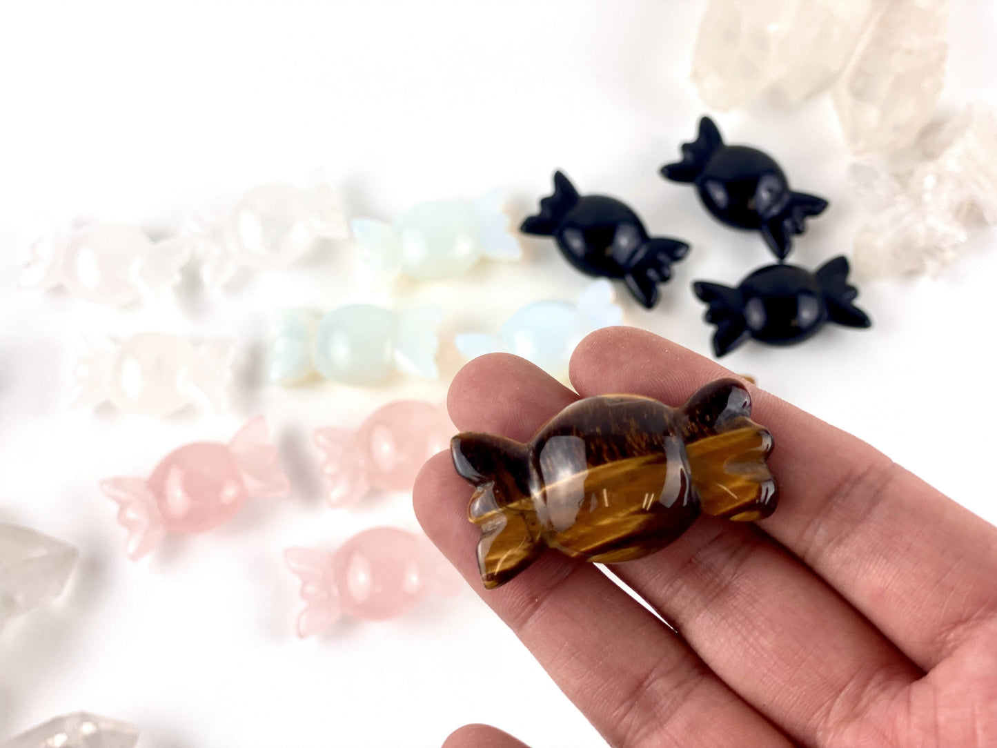 Gemstone Candy on a table spread out, with one in a hand for size reference