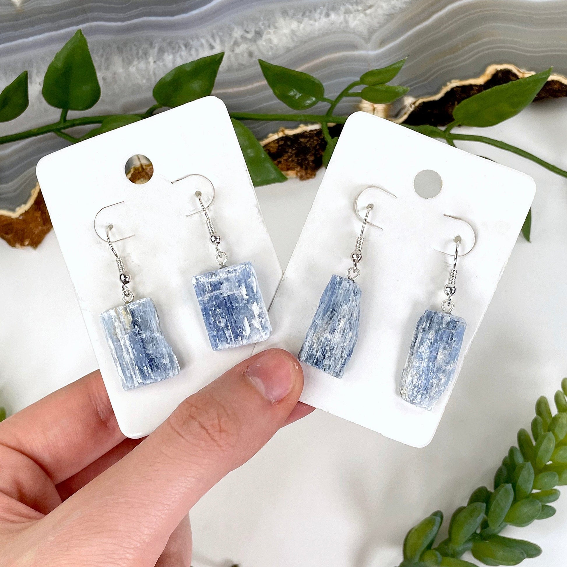two pairs of blue kyanite earrings in hand for possible variations 