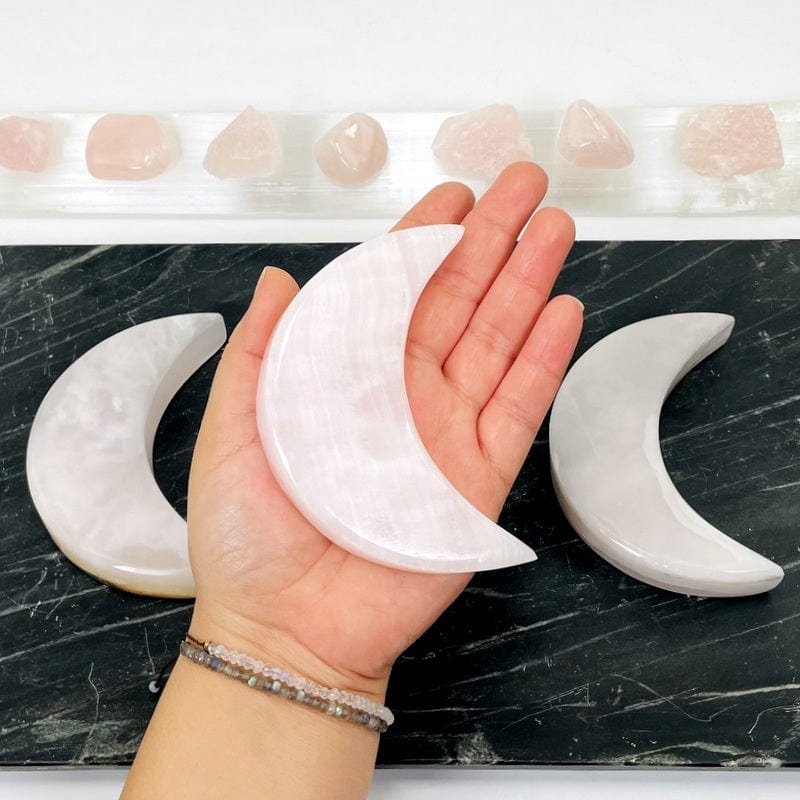 pink calcite moon in hand for size reference 