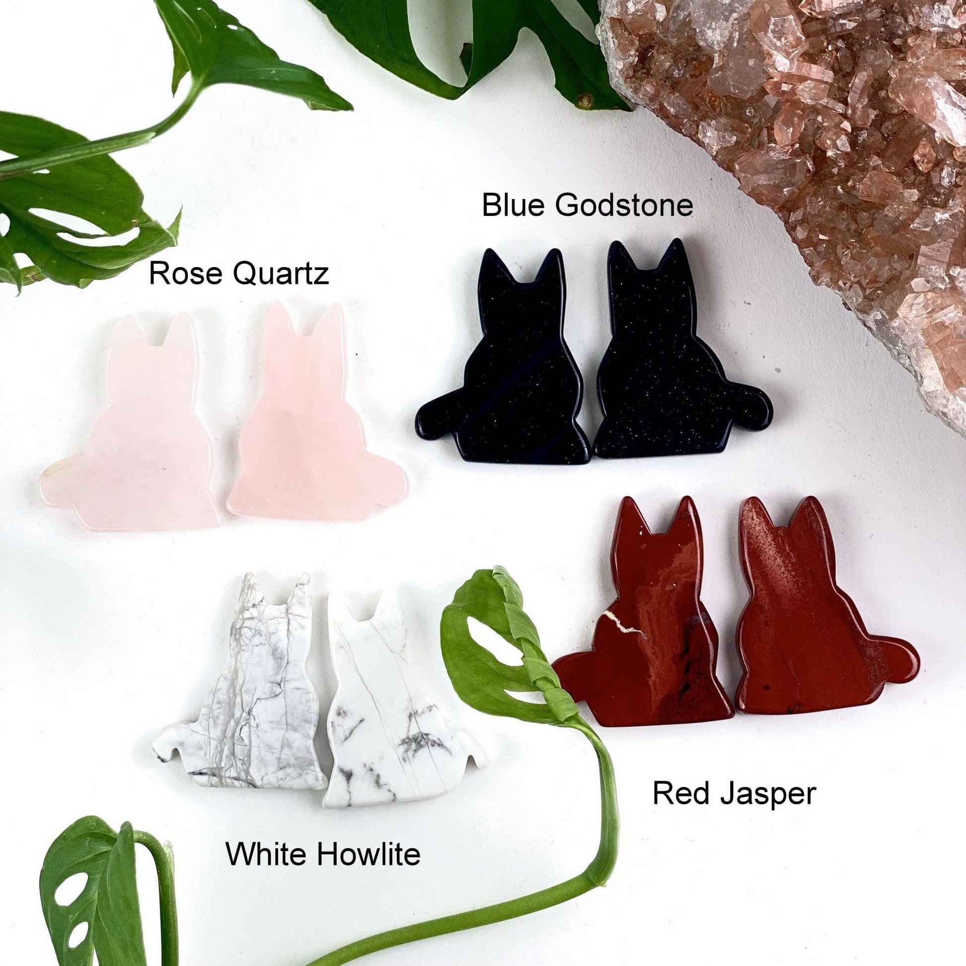 4 cat crystal variants; rose quartz (top left), blue godstone (top right), white howlite (bottom left), red jasper (bottom right) on a white background