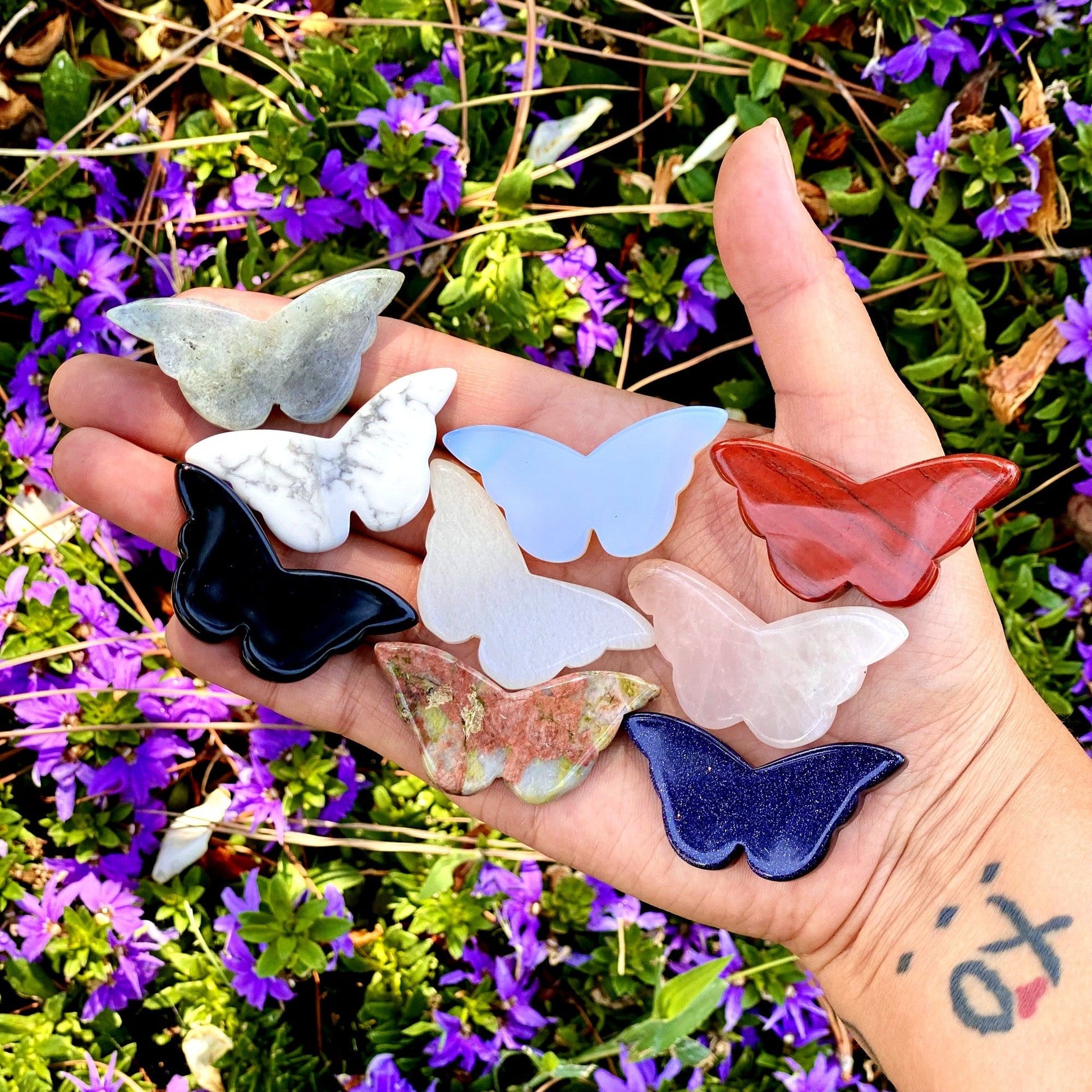 assorted butterflies in a woman's hand.  7 pieces fit in her palm