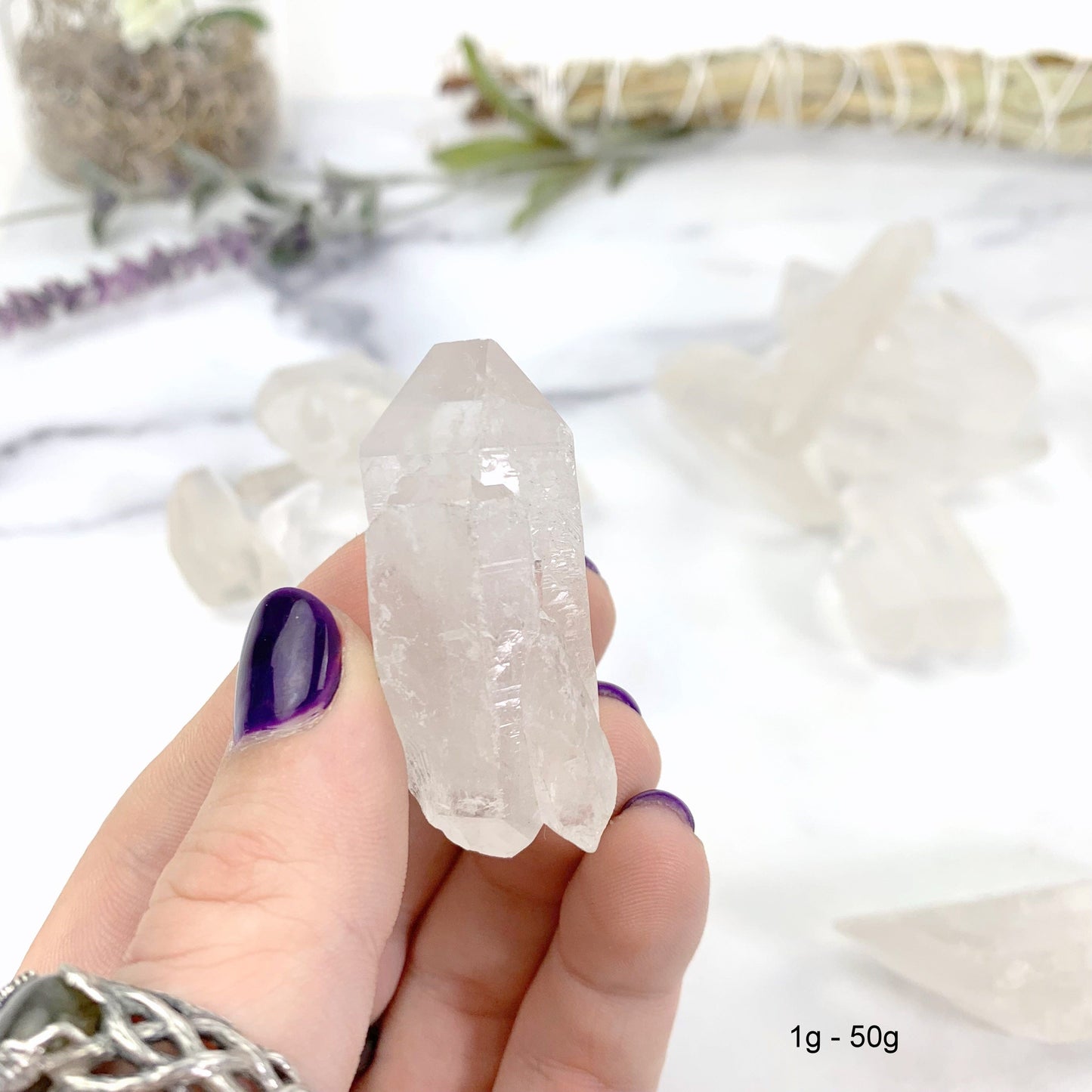 1gram - 50 gram lemurian quartz in hand with marble background