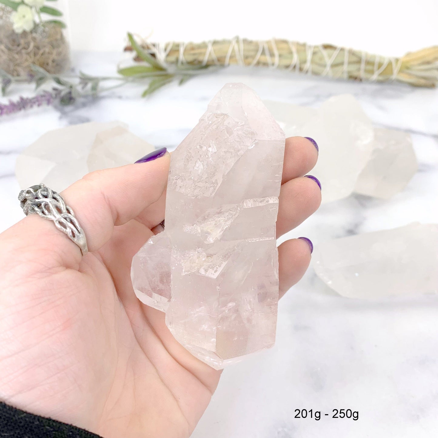 201gram - 250 gram lemurian quartz in hand with marble background